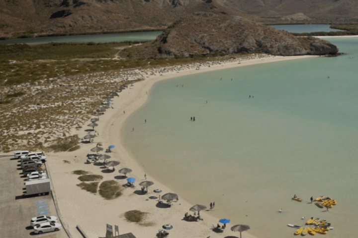 a group of people on a beach near a body of water