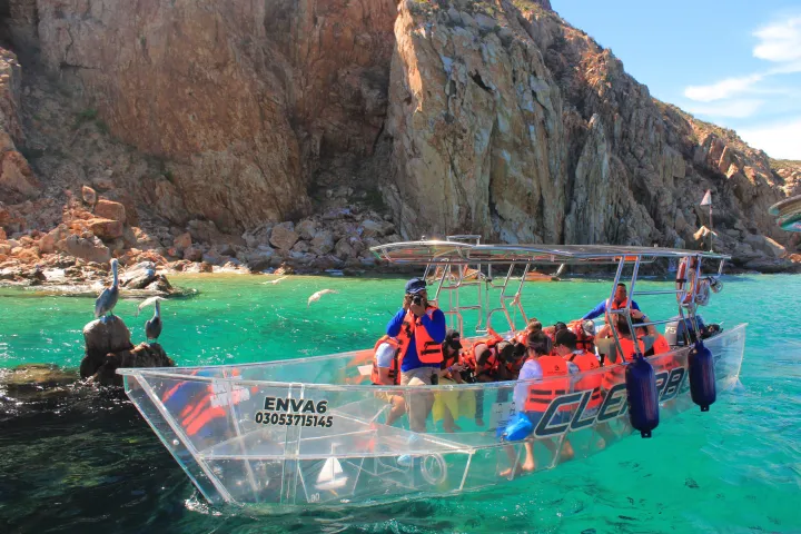 a group of people swimming in the water with a mountain in the background